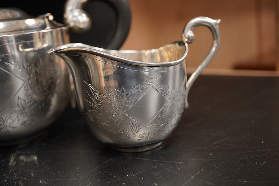 An Indian white metal three piece tea set, with engraved foliate decoration, gross weight 31.2oz.